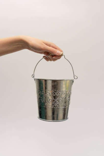 istock An iron small bucket in his hand on a white background. 1568175568