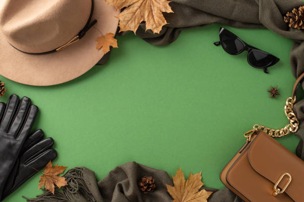 季節のファッションの必需品。濃い緑の背景にフェルトの帽子、暖かいスカーフ、トレンディな手袋、サングラス、洗練されたハンドバッグを示すトップビュー画像。プロモーションコンテ� - scarf hat green glove ストックフォトと画像