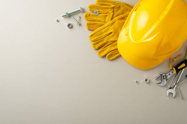 istock Saluting construction laborers on Labor Day: overhead composition displaying the American flag, construction gear, and tools on grey isolated background. Great for Labor Day campaigns or text overlays 1568180889