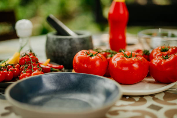 Overhead shot with copyspace of a fresh and colourful tomatoes, herbs and chillies arranged attractively on a rustic wooden table