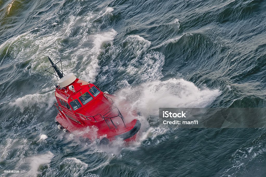 boat in a stormy sea pilot boat overcomes waves in the sea Activity Stock Photo