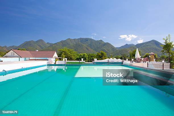 Foto de Piscina Além De Montanhas e mais fotos de stock de Arquitetura - Arquitetura, Azul, Barraca de Sol