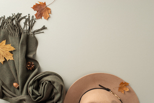 Vintage-inspired fashion accessories. Top view shot showcasing a retro cloche hat, elegant cashmere scarf on antique grey background. Perfect for nostalgic branding