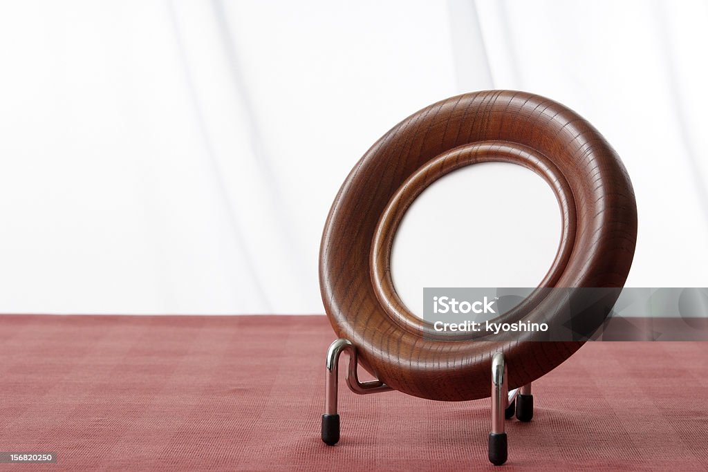 Blank wooden circle picture frame on table with copy space Blank brown wooden circle picture frame on the table in front of white curtain with copy space. Art and Craft Equipment Stock Photo