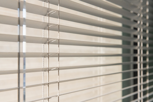 This is a photograph of the blinds covering an office window interior in Orlando, Florida in the early morning.