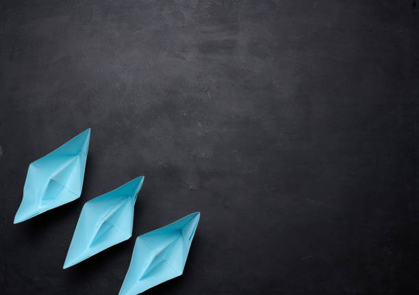 istock three blue paper boats stand in a row, teamwork. 1568223593