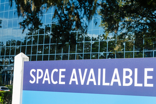 Space available sign posted out front of glass exterior office building in downtown, Orlando.
