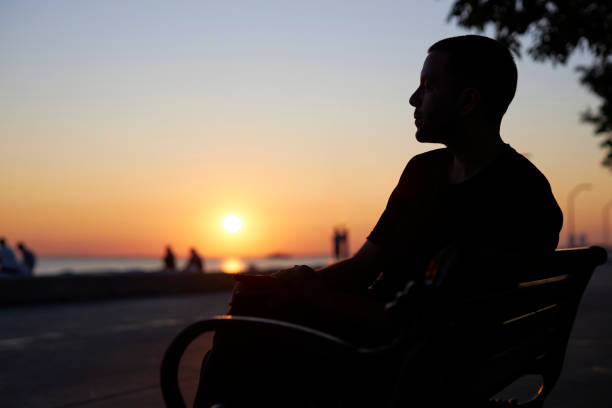 istock sitting at seaside bench on sunset time 1568317751