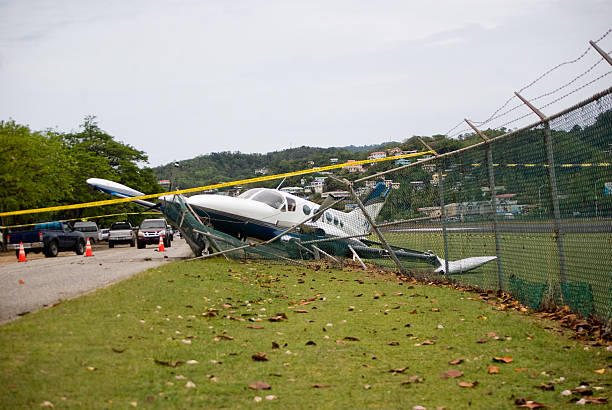 small plane crashes through fence on highway in emergency landing small plane crashes through fence in emergency landing airplane crash photos stock pictures, royalty-free photos & images