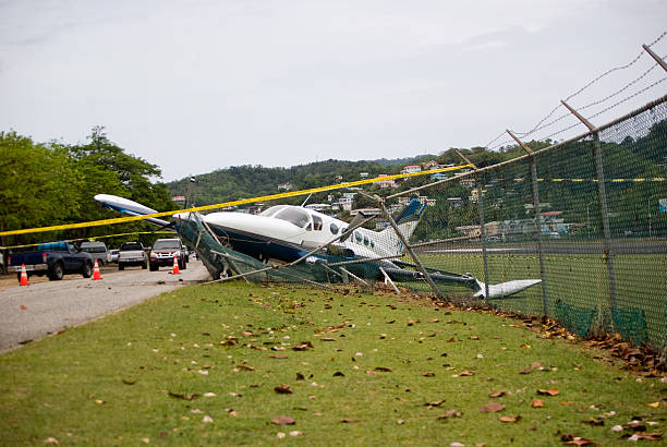 small plane crashes through fence on highway in emergency landing small plane crashes through fence in emergency landing airplane crash stock pictures, royalty-free photos & images