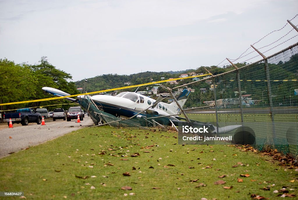 Pequeno Avião de estoiros através de vedação na estrada de emergência de aterragem - Royalty-free Acidente de Avião Foto de stock