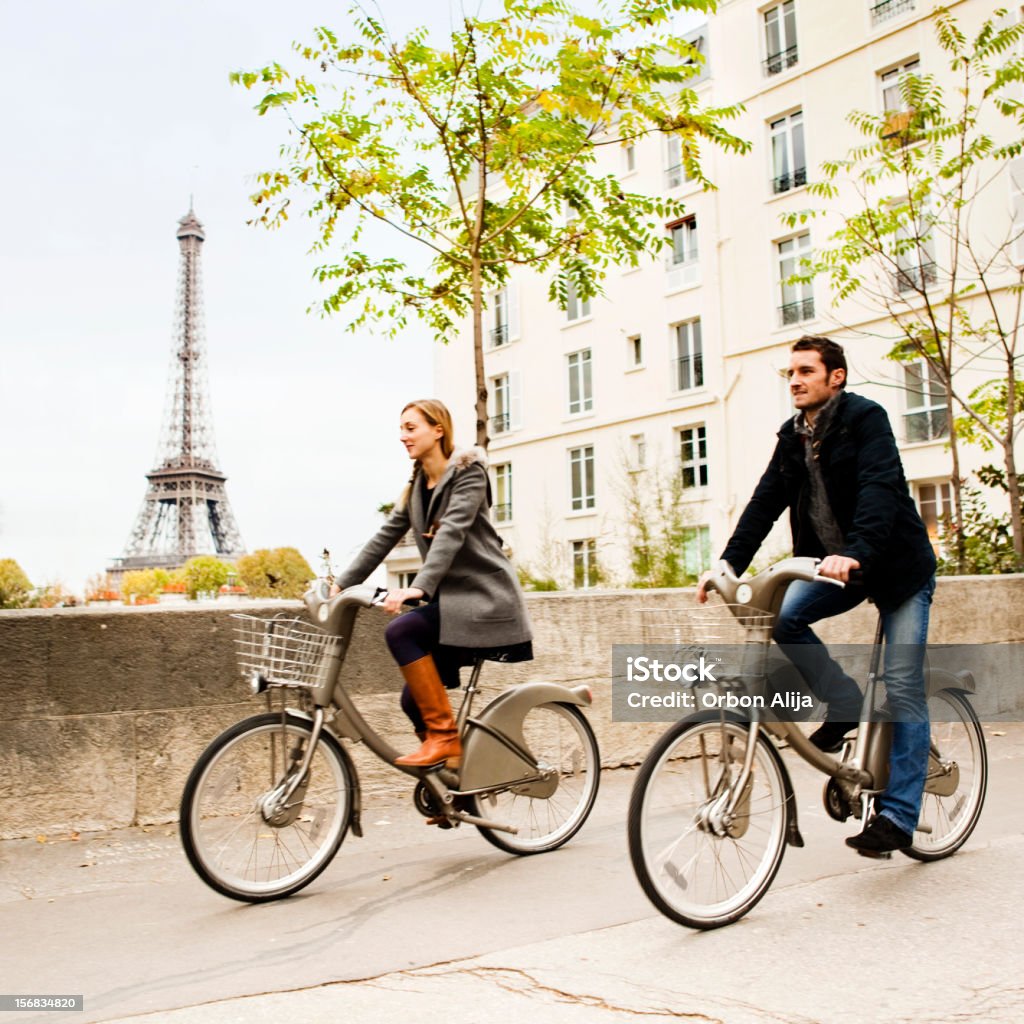 Riding in Paris Couple riding bikes in Paris Cycling Stock Photo