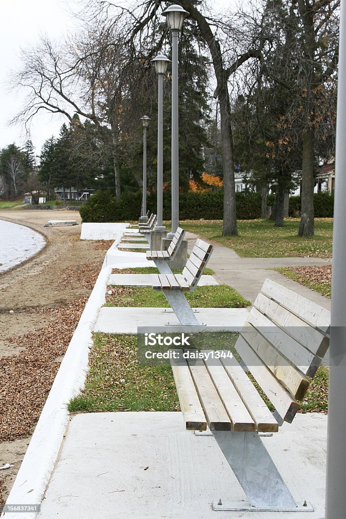 Row of benches along a beach Row of benches on cement slabs along a beach Beach Stock Photo