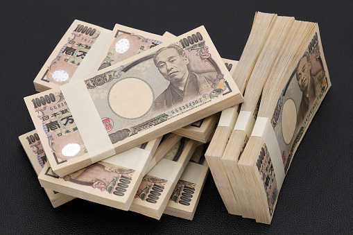 Stack of Japanese yen. 10,000 yen bundle of bills. The banknotes are written as 