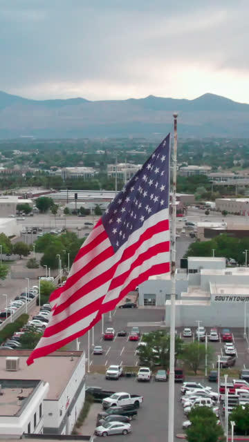 Areial Vertical Drone Shot of an American Flag Waving in Sandy Utah on A Summer Evening Before Sunset
