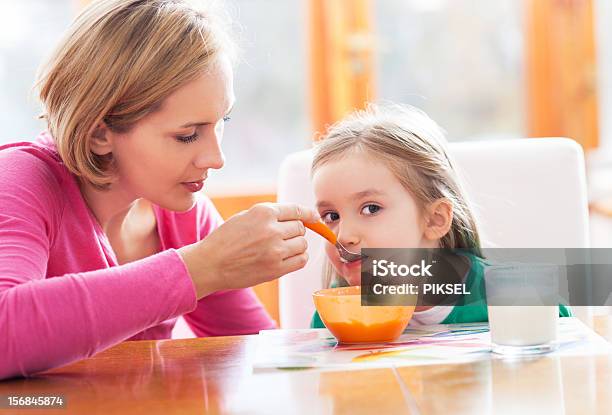 Mother Feeding Her Daughter By Spoon Stock Photo - Download Image Now - Adult, Breakfast, Child
