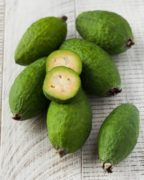 istock Ripe green feijoa on a light wooden table. Fruit. 1568487178