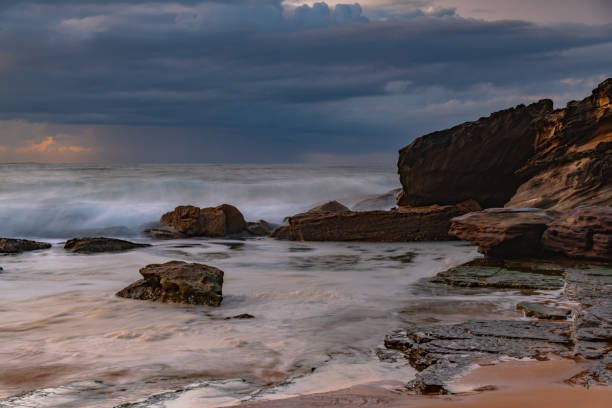 istock Sunrise seascape with low clouds and waves 1568564699