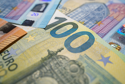 Close up of 100 euro banknote and several 20 euro banknotes in the background
