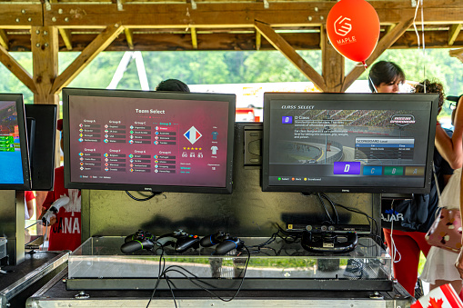 Woodbridge, Canada - July 1, 2023: People are celebrating Canada Day in Boyd Conservation Park, Volunteers are teaching children to play video games, Woodbridge, Ontario, Canada.