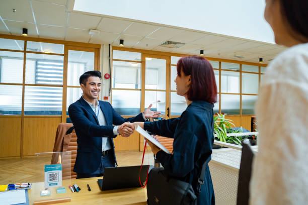 Handshake agreement, conference partnership Woman being registered for the conference, business handshake Agreement Of Both Parties stock pictures, royalty-free photos & images.