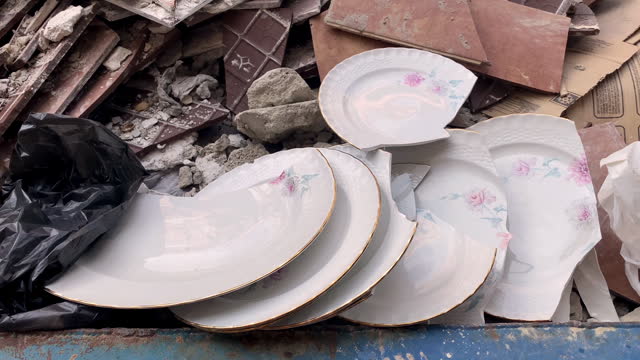 Broken classy plates inside garbage container