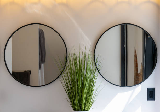istock Two oval mirrors in a bathroom on a white wall. 1568669350
