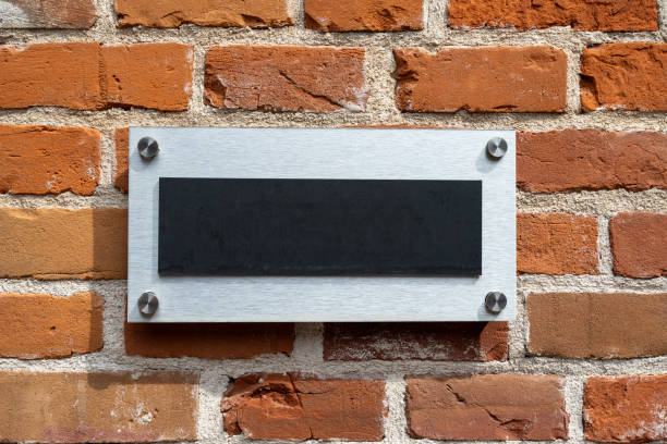 istock Blank metal sign on a brick wall. 1568669375
