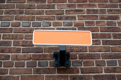 Blank sign on a brick wall for advertising.