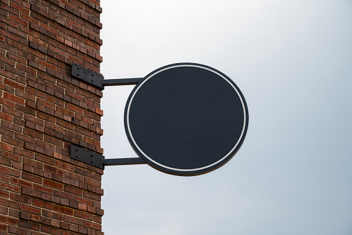 Blank round sign on a brick building for mock-ups