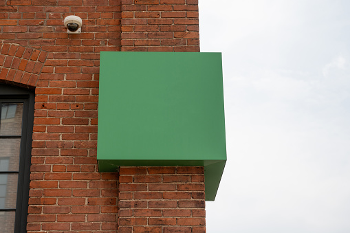 Blank green sign on a brick building