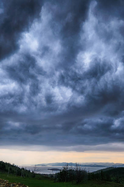 istock Cloudy sky over a lake surrounded by mountains. dark blue  cloudy sky over the lake. Dramatic cloudy sky over the lake. 1568696932