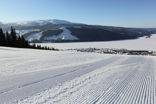 View from the top of a snow ski slope in Åre, Sweden.  Depth of field with focal point on groomed snow in foreground.   Please see my other Åre snow photos... 
