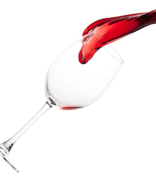 Pouring red wine in a glass stock photo