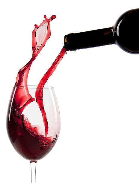 Pouring red wine in a glass stock photo
