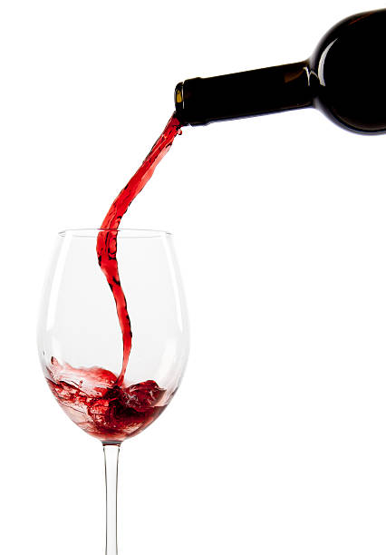 Pouring red wine in a glass stock photo