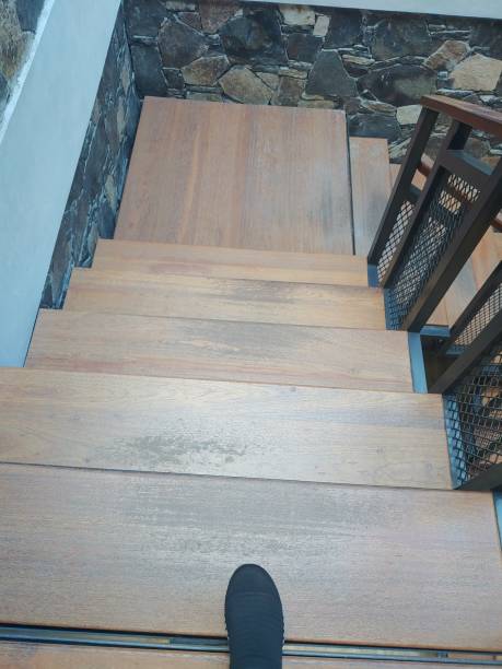 istock A shoes on wooden Staircase with stone wall background - moving down concept 1568744004