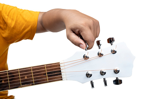 Human Hand Tuning Guitar on Isolated White Background