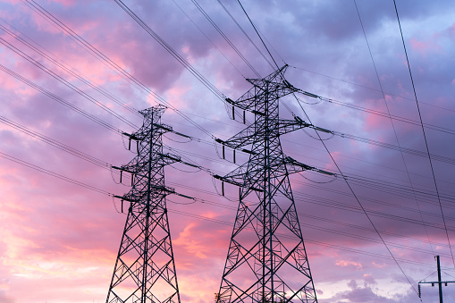 high voltage line transmission tower at sunset