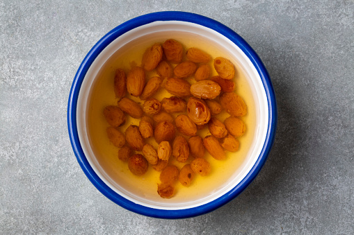 Top view of white bowl full of dried apricots