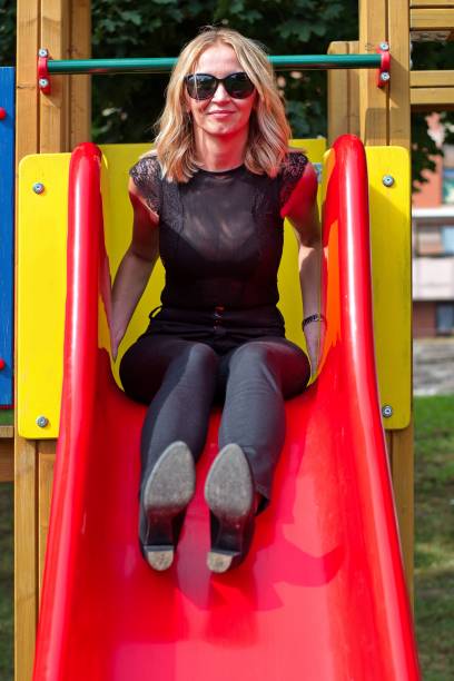 istock Mature woman having fun on a playground 1568749504