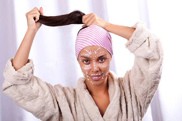 belle jeune femme dans un centre de spa en tirant ses cheveux - towl photos et images de collection