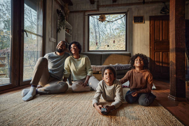 istock Happy black family enjoying while watching TV at home. 1568757548