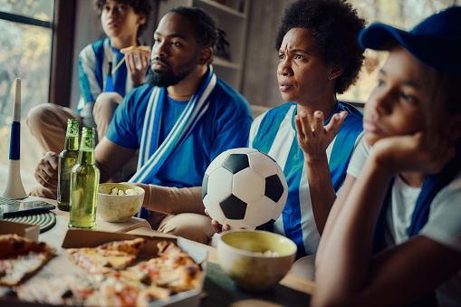 African American family feeling frustrated after their favorite soccer team has lost the match.