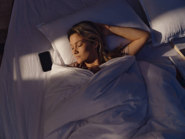 istock Above view of relaxed woman sleeping in bed. 1568769532