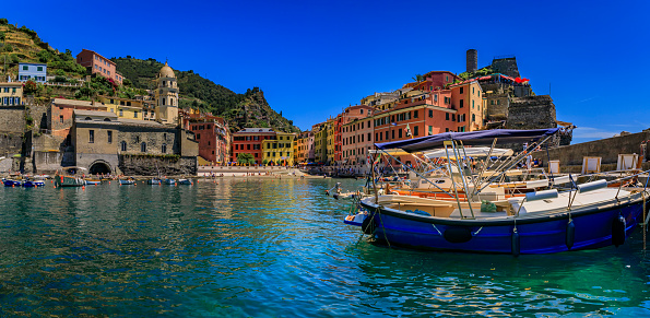 Mediterranean Sea with traditional boats, colorful houses and Santa Margherita di Antiochia Church in Vernazza, Cinque Terre, Italy