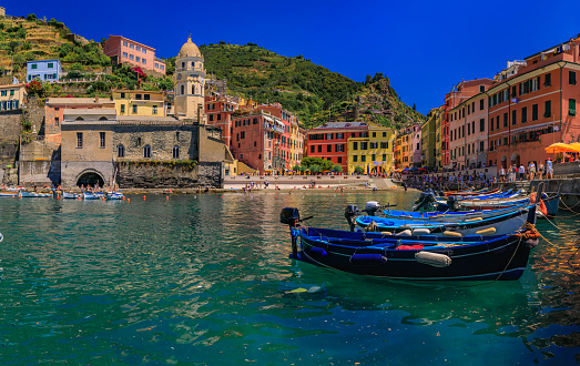Mediterranean Sea with traditional boats, colorful houses and Santa Margherita di Antiochia Church in Vernazza, Cinque Terre, Italy