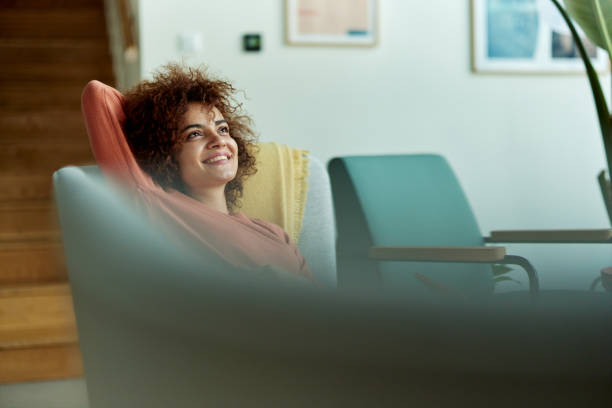 istock Happy woman relaxing on sofa at home. 1568794721