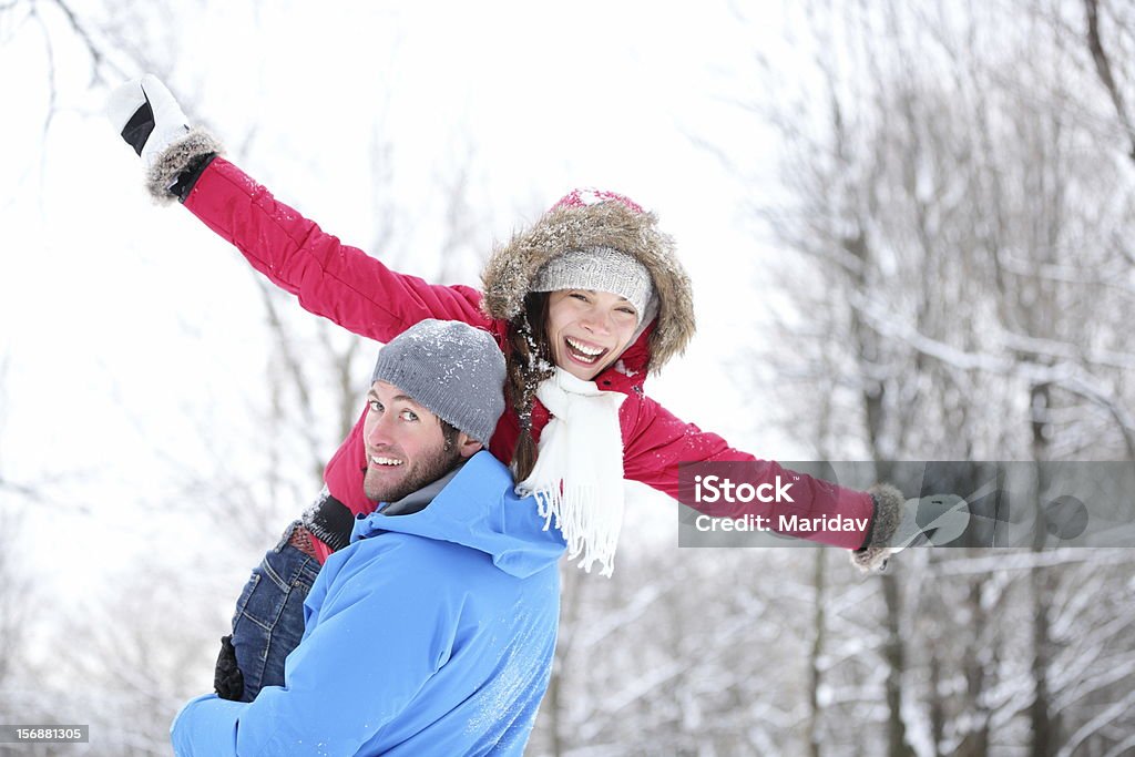 Winter fun couple Winter fun couple playful together during winter holidays vacation outside in snow forest. Happy young interracial couple, Asian woman, Caucasian man. Couple - Relationship Stock Photo