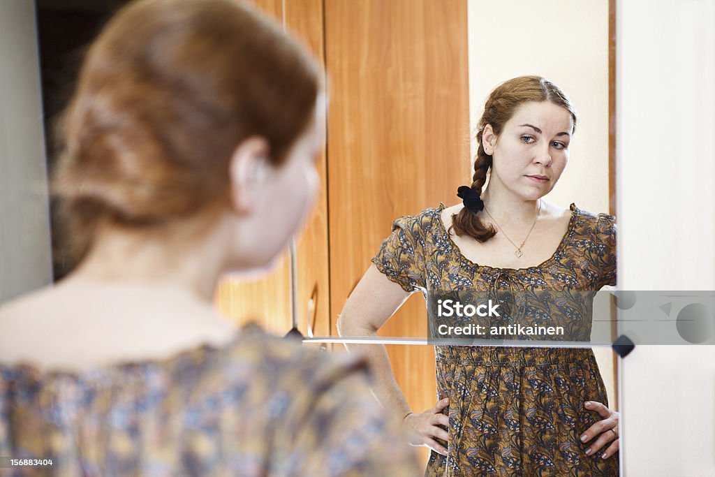 Donna in un abito in piedi contro il trucco - Foto stock royalty-free di Abbigliamento